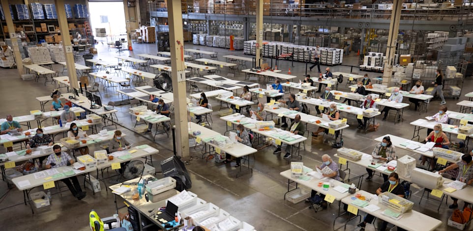 עובדי בחירות בודקים מעטפות עם פתקי הצבעה / צילום: Reuters, מייק בלייק