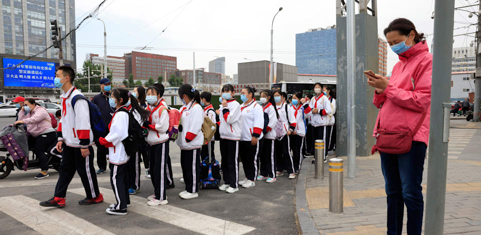תלמידים בבייג'ין חוצים את הכביש בדרך לבית הספר / צילום: Associated Press, Ng Han Guan