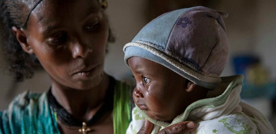 אם ובנה שסובל ממת תזונה במחוז טיגיריי, אתיופיה. לפי דוח של האו''ם 79% מהנשים ההרות או המניקות שנבדקו באזור סובלות מתת תזונה קיצונית / צילום: Associated Press, Christine Nesbitt