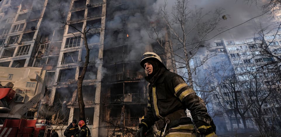 כבאי ליד בית דירות מופגז בקייב, ביום שלישי / צילום: Associated Press, Vadim Ghirda