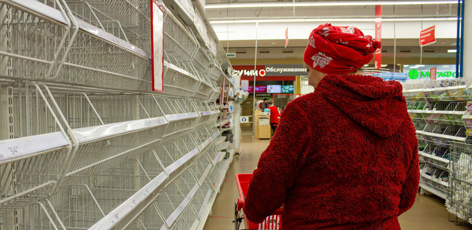אישה מתהלכת בין מדפים ריקים בסופרמרקט במוסקבה / צילום: Reuters, Vlad Karkov/SOPA Images