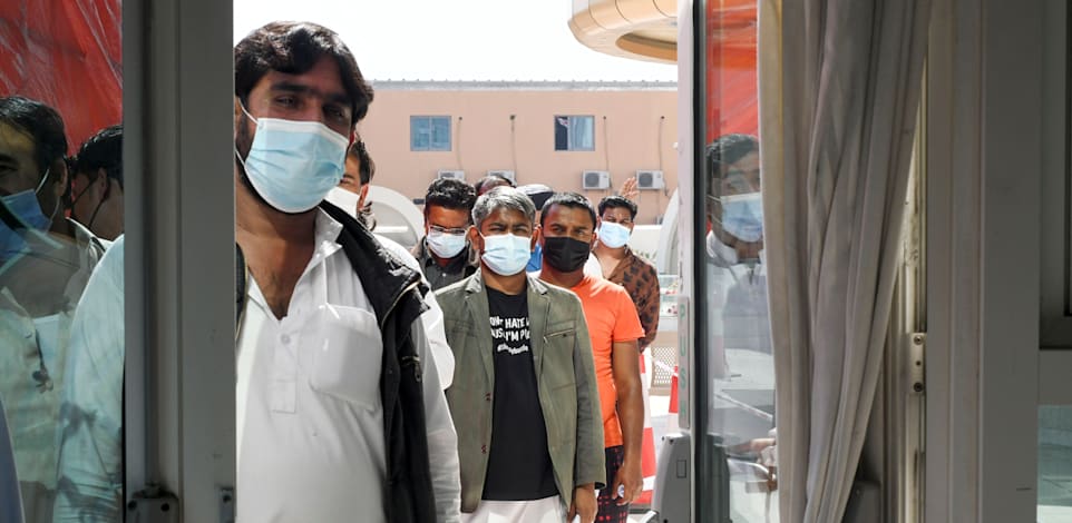 אנשים עומדים בתור כדי לקבל חיסון לקורונה באבו דאבי / צילום: Reuters, Khushnum Bhandari