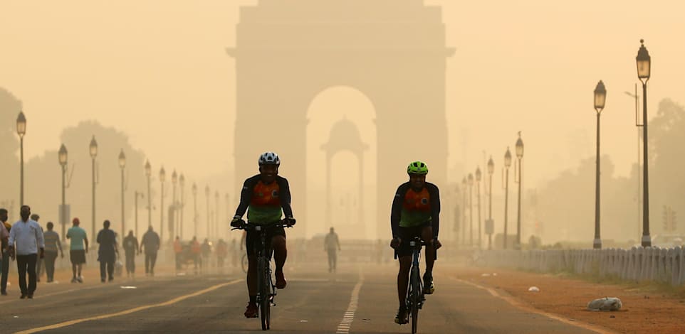 רוכבי אופניים בניו דלהי המזוהמת / צילום: Reuters, Adnan Abidi