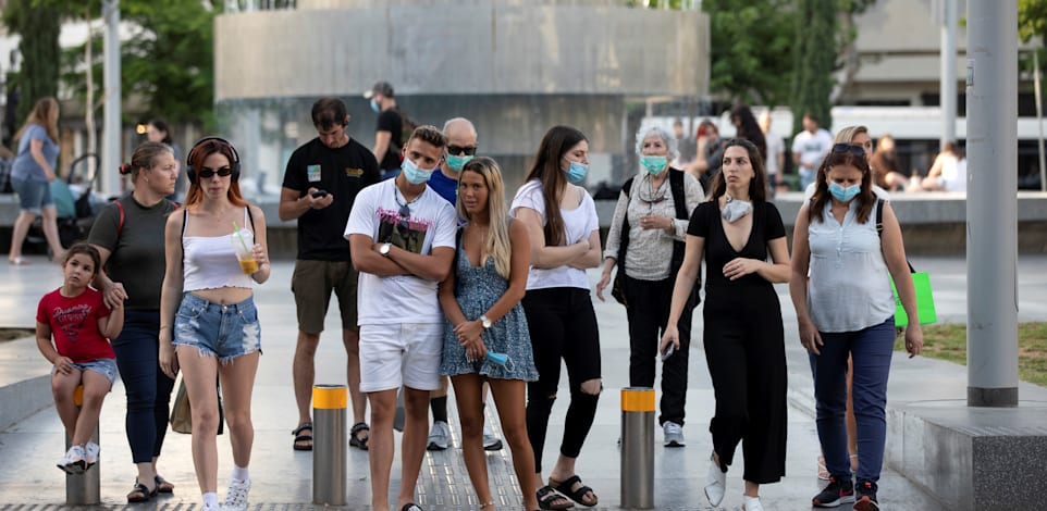 אנשים עומדים במעבר חצייה בתל אביב ביוני האחרון / צילום: Reuters, Amir Cohen