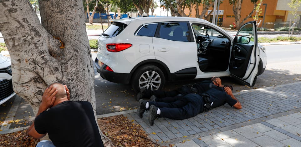 תושבים באשקלון תופסים מחסה בזמן נפילת הרקטות / צילום: Associated Press, Ariel Schalit