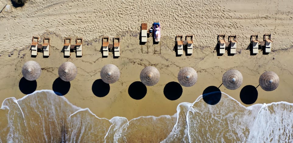 חוף באי פלאקה באי היווני נקסוס, החודש. אירופה מצחצחת  את אתרי התיירות ומקווה שהתיירים לא יחששו לבוא / צילום: Thanassis Stavrakis PA