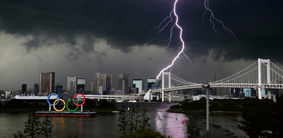 ברק בשמי טוקיו ליד סמל האולימפיאדה / צילום: Associated Press, Kyodo News
