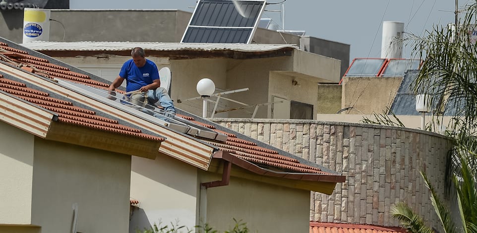 התקנת פאנלים סולאריים בבית מגורים / צילום: Shutterstock