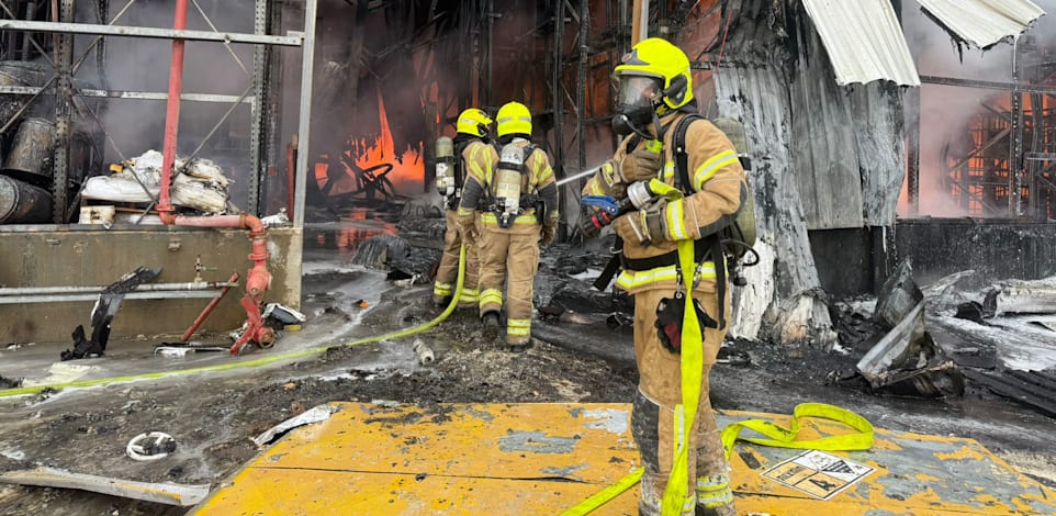 לוחמי אש מכבים את האש שפרצה לאחר פגיעת חלק יירוט באזור נאות חובב / צילום: כבאות והצלה לישראל