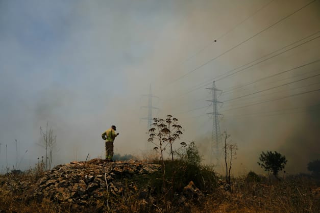 כבאי מנסה לכבות את האש של השריפות שפרצו בגבול הצפון בעקבות ירי כטב''מים של חיזבאללה / צילום: ap, Ariel Schalit