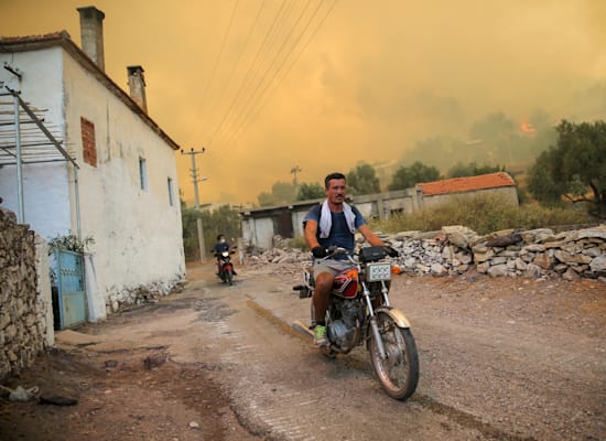 אדם בורח מהאש בעירייה קוקרטמה, שסמוכה לבודרום בטורקיה / צילום: Associated Press, Emre Tazegul