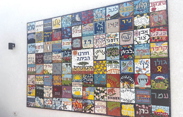קיר הפסיפס שבו משובצים שמות המשפחות שחזרו להתגורר בקיבוץ, נירים / צילום: הילה ויסברג