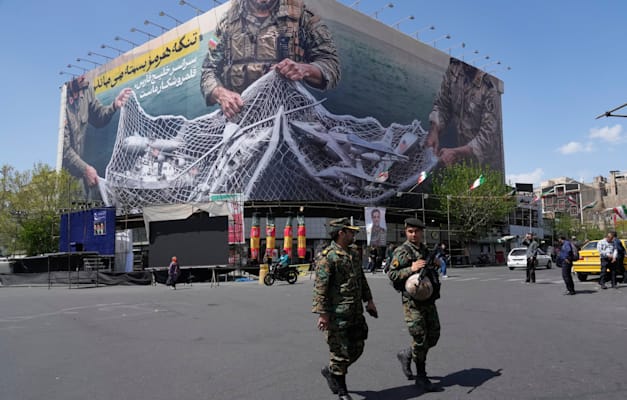 שני שוטרים בטהרן הולכים מול שלט המתאר את המטוסים האמריקאים נופלים לתוך הרשת של משמרות המהפכה / צילום: ap, Vahid Salemi שני שוטרים בטהרן הולכים מול שלט המתאר את המטוסים האמריקאים נופלים לתוך הרשת של משמרות המהפכה / צילום: ap, Vahid Salemi