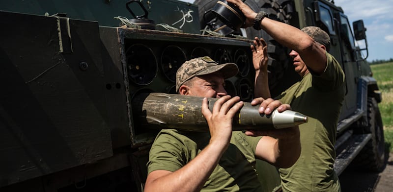 חייל אוקראיני נושא פגז 155 מ''מ / צילום: Associated Press, Evgeniy Maloletka