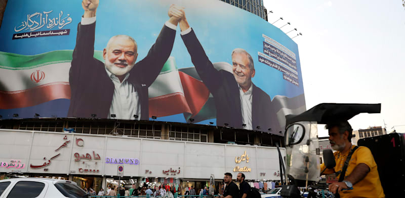 כרזה שבה נראה איסמעיל הנייה משלב ידיים עם נשיא איראן מסעוד פזשכיאן / צילום: ap, Vahid Salemi