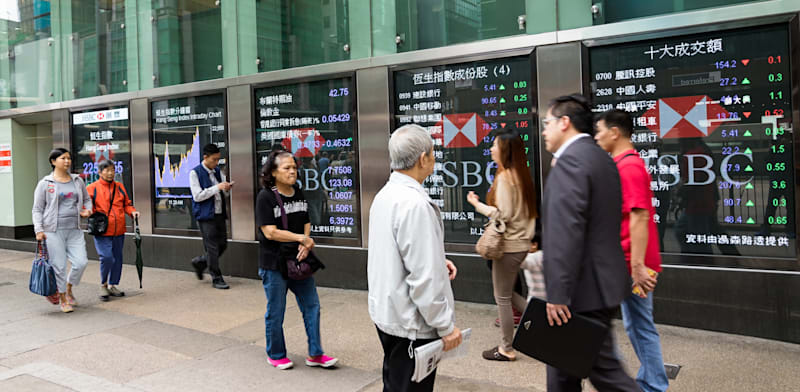 "הולכי רגל חולפים על פני מסך תצוגה פיננסי בהונג קונג / צילום: Shutterstock"