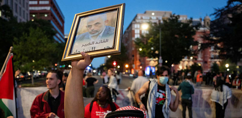 "מפגין פרו-פלסטיני מחזיק בתמונה של סינוואר בהפגנה לקראת ה-7 באוקטובר ליד הבית הלבן בוושינגטון / צילום: Reuters, Seth Herald"