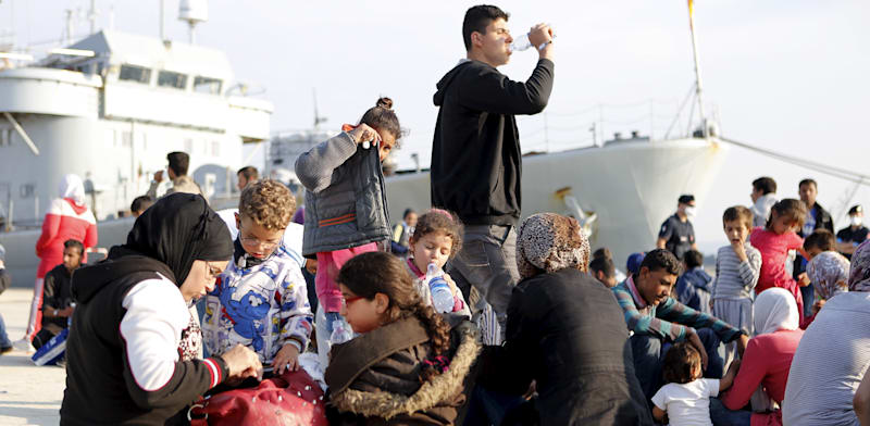 פליטים סורים יורדים מספינה בלגית בנמל באיטליה / צילום: Reuters, Antonio Parrinello