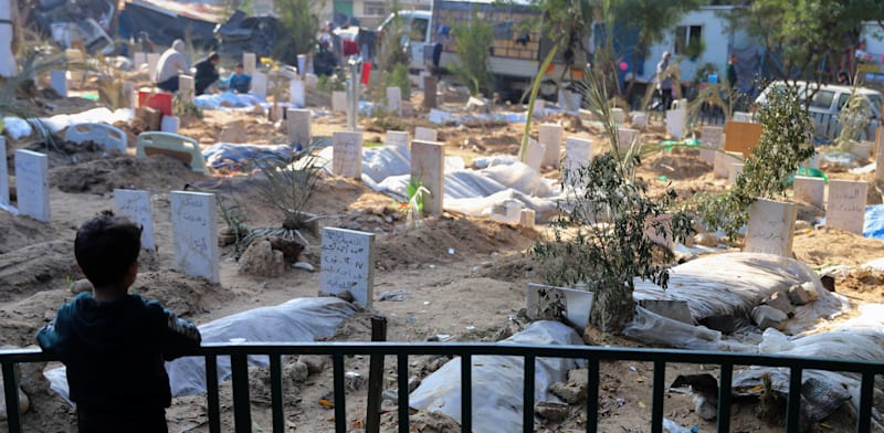 "ילד משקיף על בית קברות מאולתר בעיר עזה. התקשורת העלימה האמת / צילום: ap, Mohammed Hajjar"