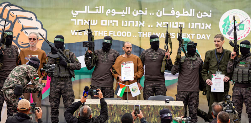 אור לוי, אלי שרעבי ואוהד בן עמי לפני העברתם מידי חמאס לידי הצלב האדום / צילום: Associated Press, Abdel Kareem Hana