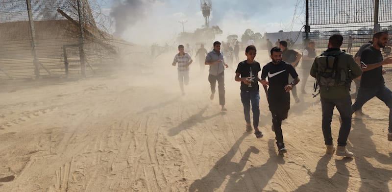 "עזתים חוצים את הגדר ב-7 באוקטובר / צילום: Reuters, Hani Alshaer / Anadolu Agency"