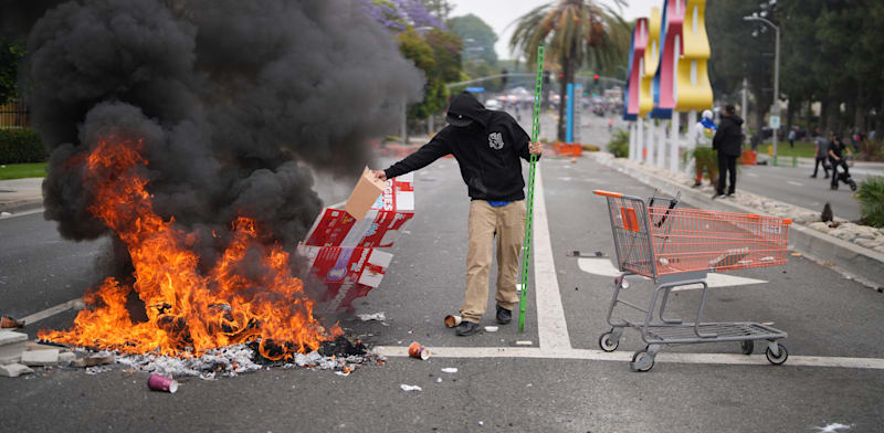 "מפגין מבעיר אש במהלך הפגנה בפרמאונט, קליפורניה, לאחר שסוכנויות הגירה פדרליות ביצעו פעולות במקום / צילום: ap, Eric Thayer"