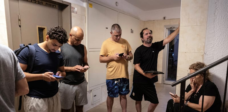 תושבים בתל אביב בחדר המדרגות לאחר השמעת האזעקה עם פתיחת המתקפה באיראן / צילום: Reuters, Itay Cohen