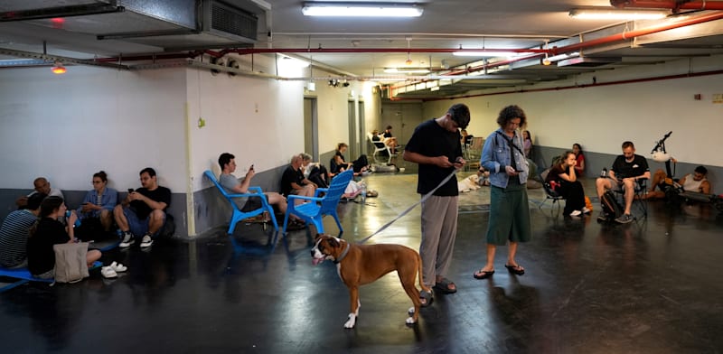 "אזרחים מחכים בחניון בתל אביב בזמן ירי מאיראן / צילום: ap, Baz Ratner"