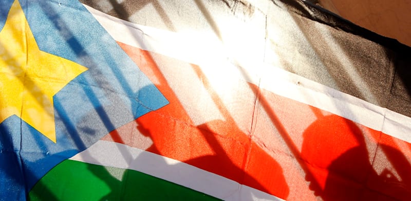 "צלליות אזרחים אנשים מבעד לדגל דרום סודן / צילום: ap, Jerome Delay"