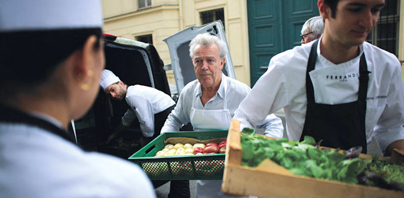 "אלן פאסאר, מוקף בצוות הטבחים שלו, עם ארגזי ירקות מגינתו, בחודש שעבר / צילום: Reuters, Gonzalo Fuentes TPX"