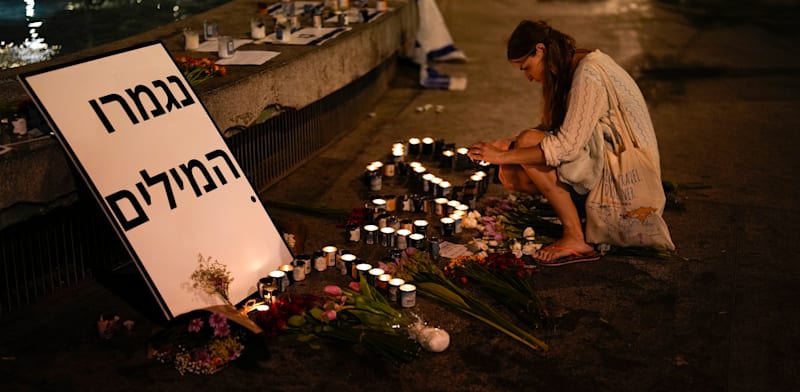 "אישה מדליקה נרות נשמה בכיכר דיזנגוף בתל אביב, 13 באוקטובר 2023 / צילום: ap, Francisco Seco"