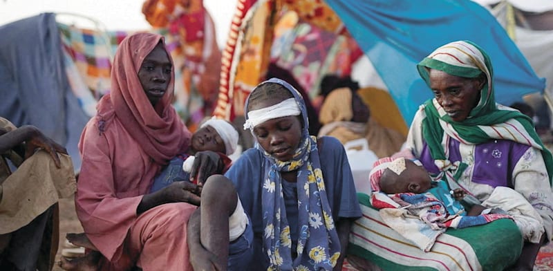 "משפחה שברחה מאל-פאשר יושבת במחנה פליטים בצפון סודן / צילום: Reuters, Mohammed Jamal"