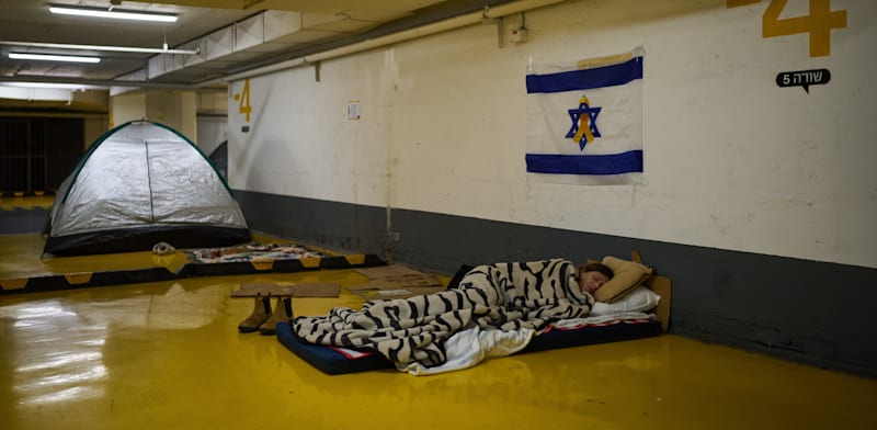 אישה ישנה בחניון תת-קרקעי בתל אביב / צילום: ap, Oded Balilty