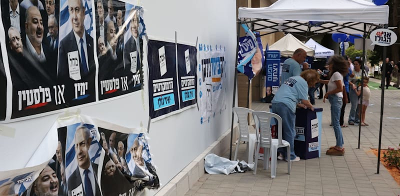 פעילים עומדים מחוץ לקלפי בהרצליה / צילום: Reuters, Gil Cohen