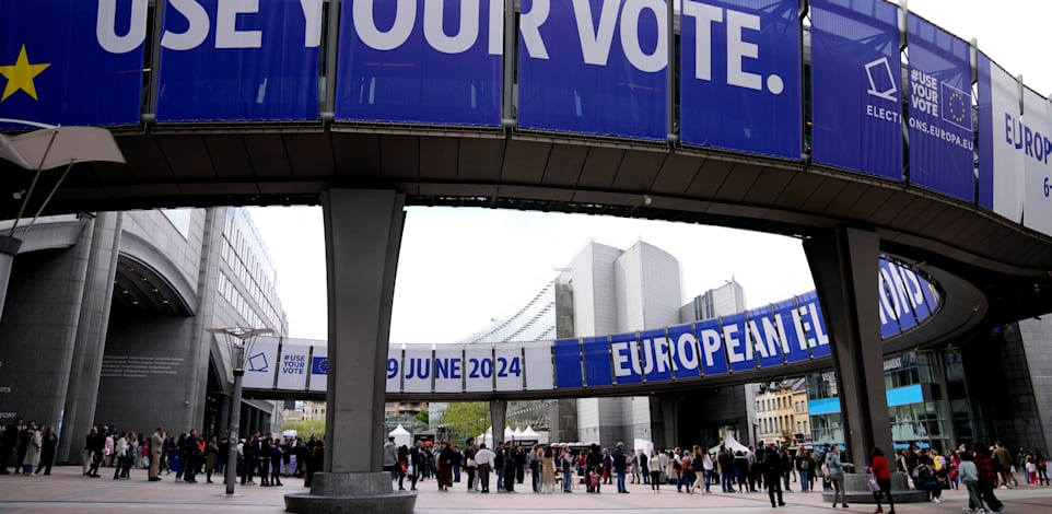תור של אנשים בכניסה לפרלמנט האירופי ושלטים לקראת הבחירות / צילום: ap, Virginia Mayo