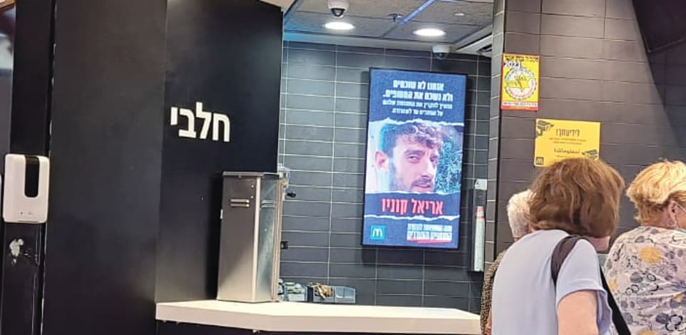 מסך עם תמונות חטופים בסניף מקדונלד'ס / צילום: טלי בוגדנובסקי