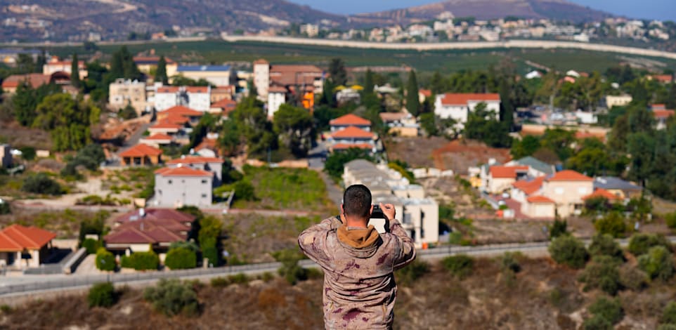 איש חיזבאללה מצלם את מטולה בחודש שעבר / צילום: ap, Bilal Hussein