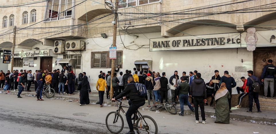 תושבי עזה עומדים בתור למשוך כסף מסניף של בנק פלסטין, אתמול (ו') / צילום: Reuters, Abed Rahim Khatib