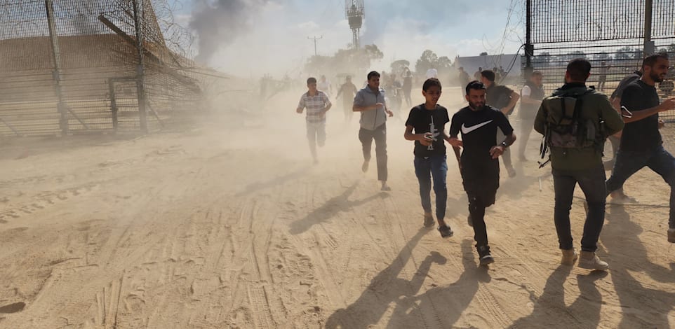 עזתים חוצים את הגדר ב-7 באוקטובר / צילום: Reuters, Hani Alshaer / Anadolu Agency