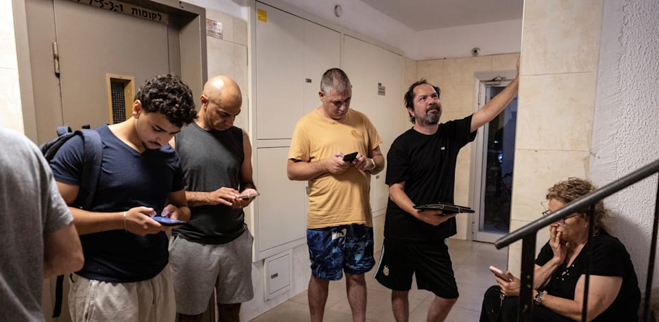 תושבים בתל אביב בחדר המדרגות לאחר השמעת האזעקה עם פתיחת המתקפה באיראן / צילום: Reuters, Itay Cohen