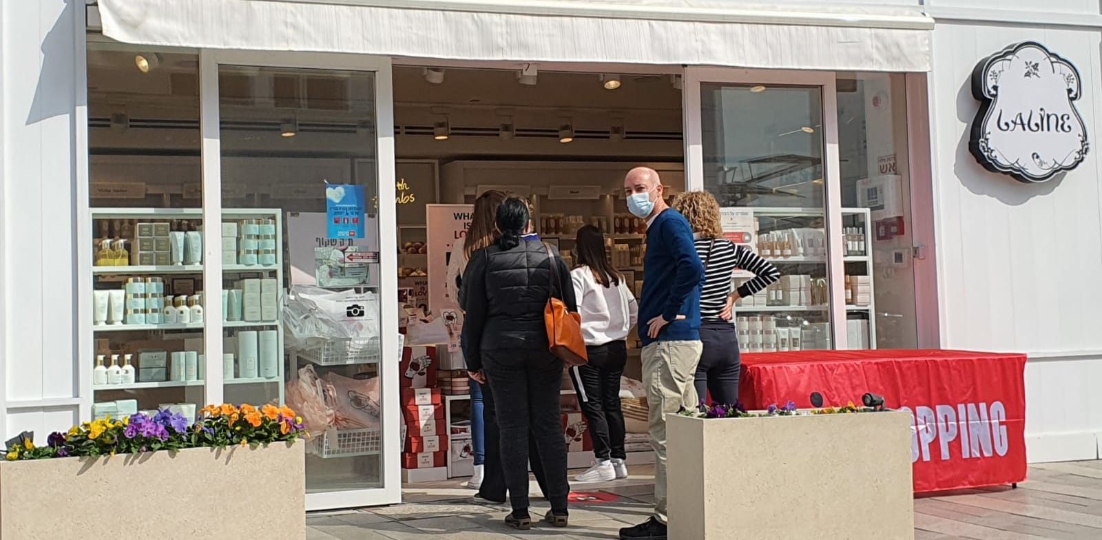 אנשים עומדים בתור לחנות ללין במרכז ביג בקריות. רשתות רבות נפתחו בניגוד להנחיות הסגר / צילום: פאול אורלייב