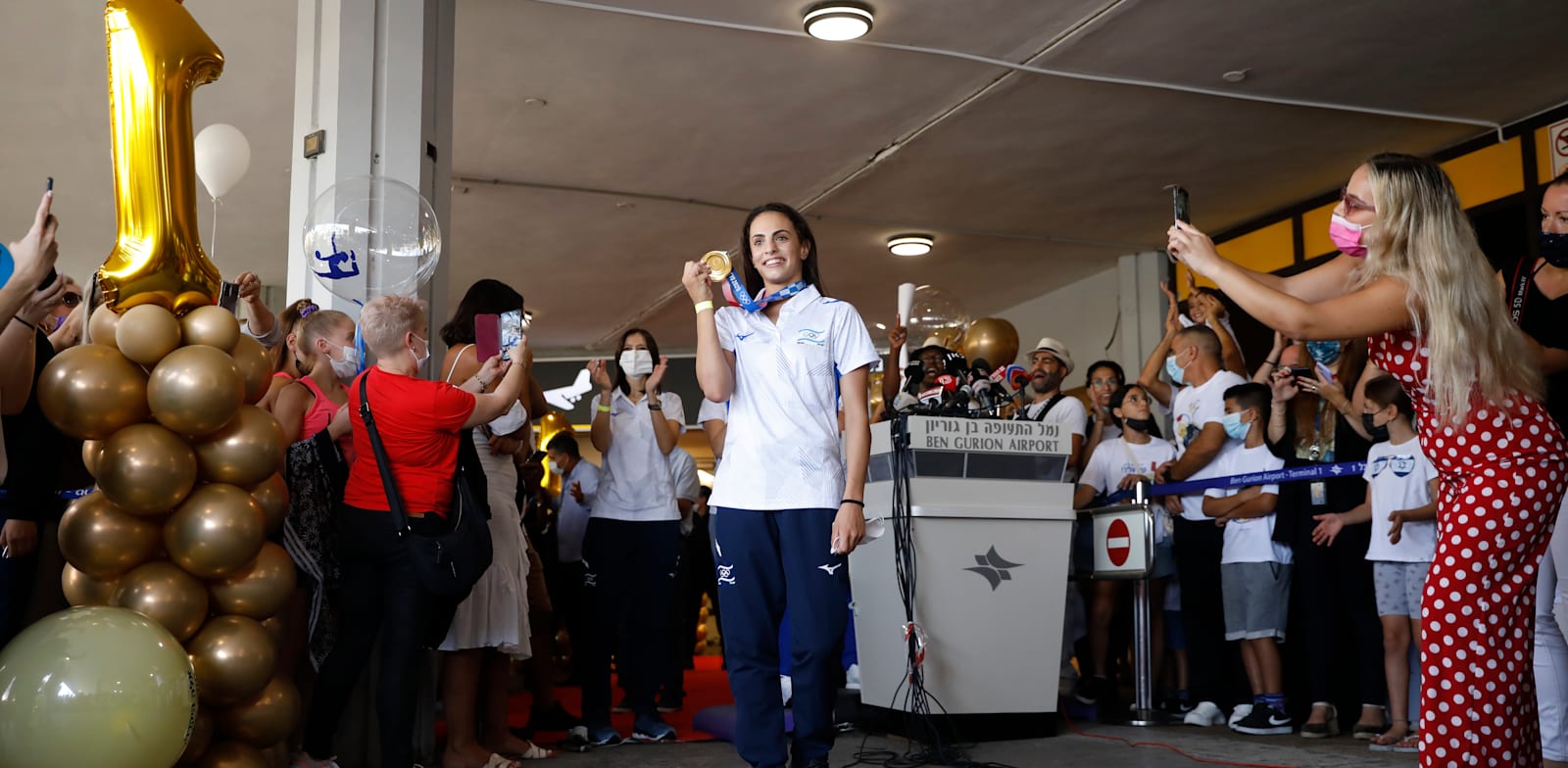 לינוי אשרם מציגה את מדליית הזהב לאחר הנחיתה ארצה / צילום: Associated Press, Ariel Schalit