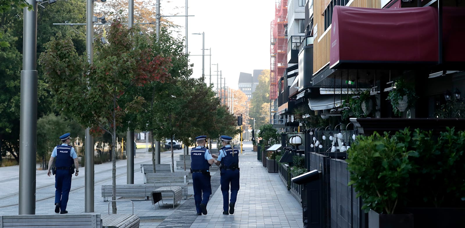 פקחים מסיירים בשדרת עסקים ריקה בניו זילנד. הרשויות איתרו לפחות שבעה מקרים של קורונה בקהילה / צילום: Associated Press, Mark Baker