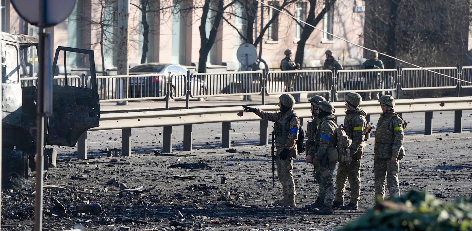 חיילים אוקראינים עומדים ליד משאית צבאית שעולה באש, בקייב / צילום: Associated Press, Efrem Lukatsky