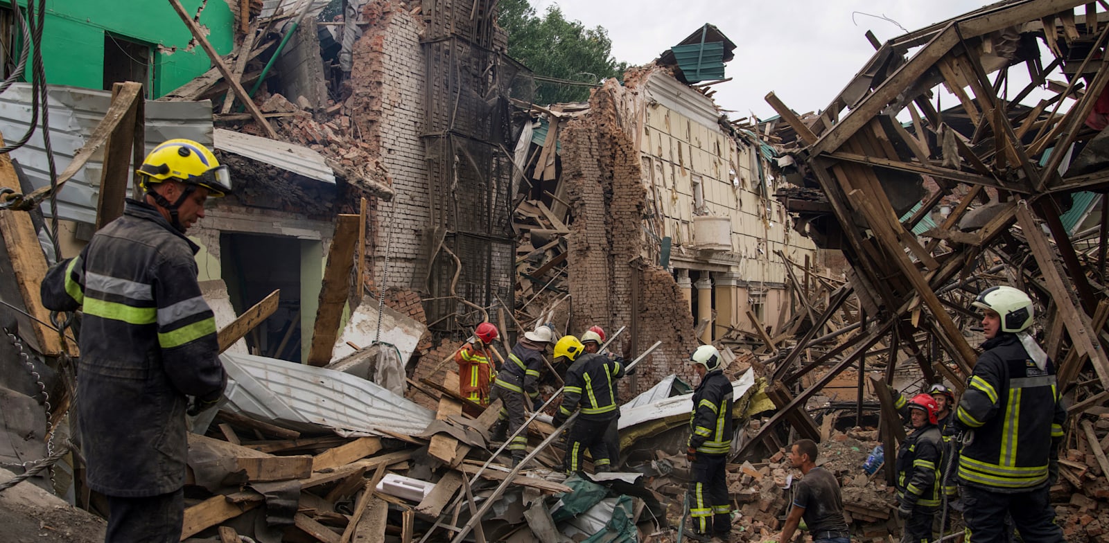 כוחות ביטחון אוקראיניים מפנים הריסות בניין לאחר פגיעה של טיל רוסיה / צילום: Associated Press, Evgeniy Maloletka