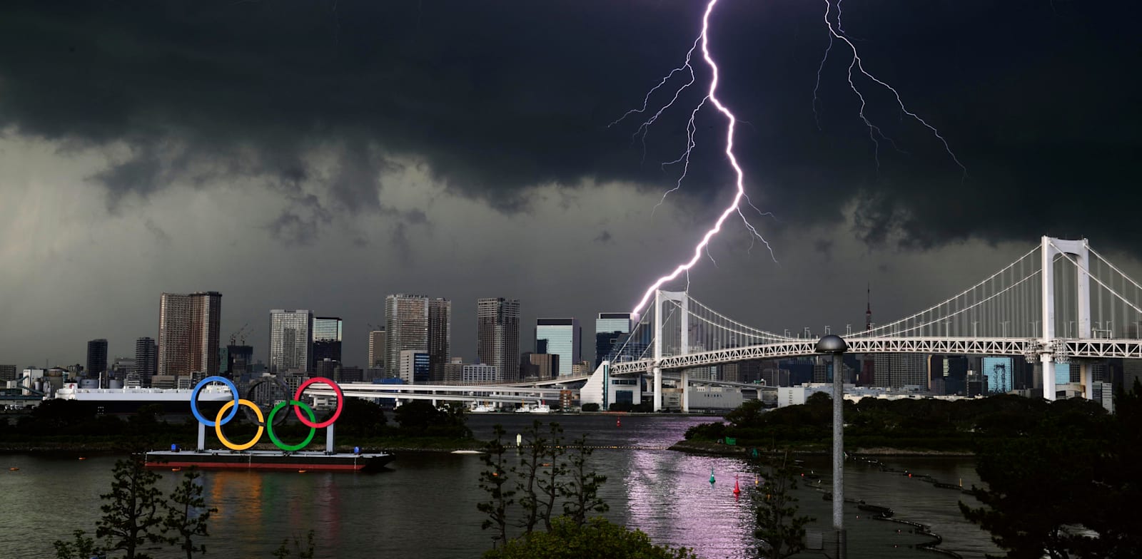 ברק בשמי טוקיו ליד סמל האולימפיאדה / צילום: Associated Press, Kyodo News