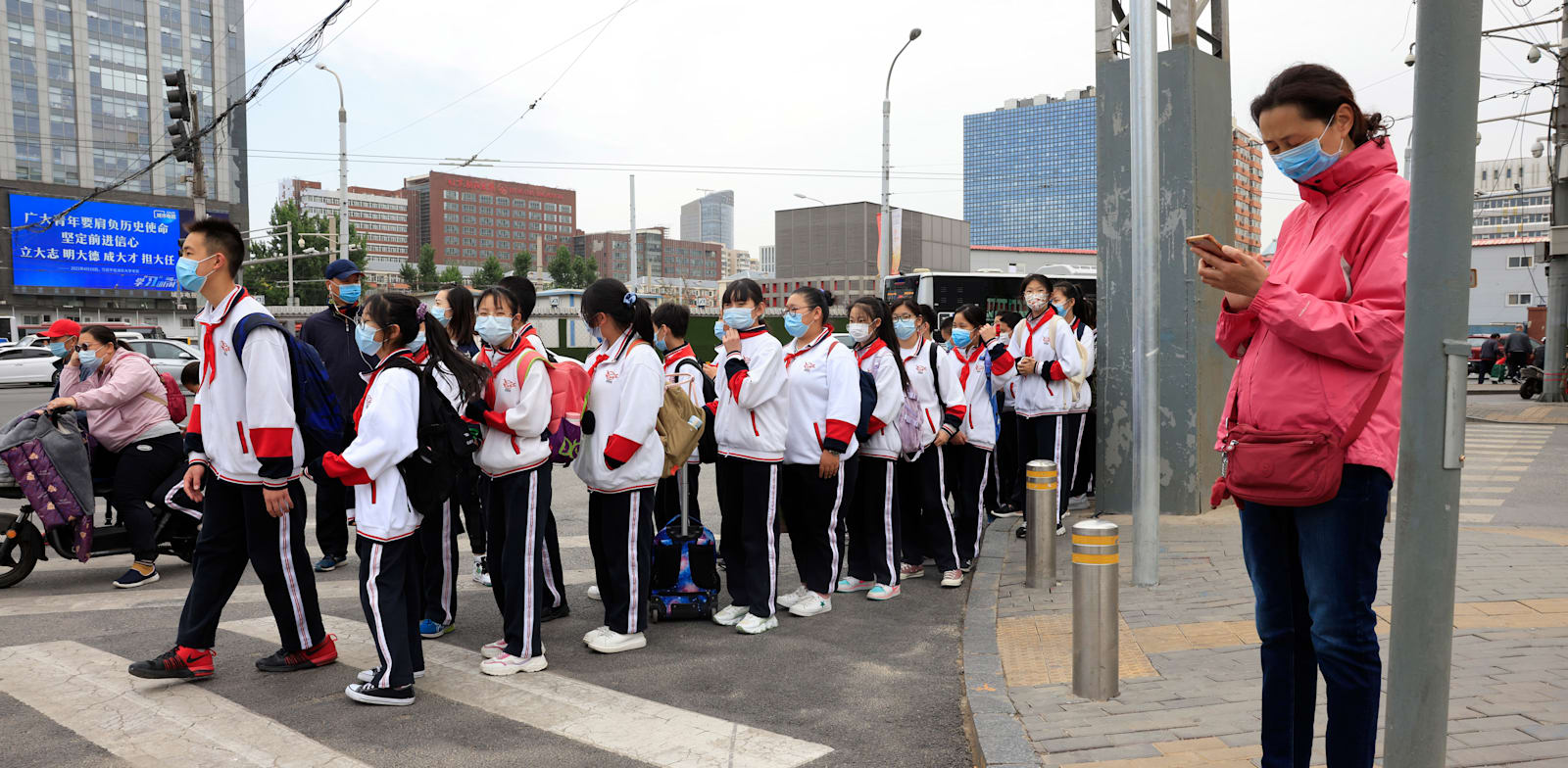 תלמידים בבייג'ין חוצים את הכביש בדרך לבית הספר / צילום: Associated Press, Ng Han Guan