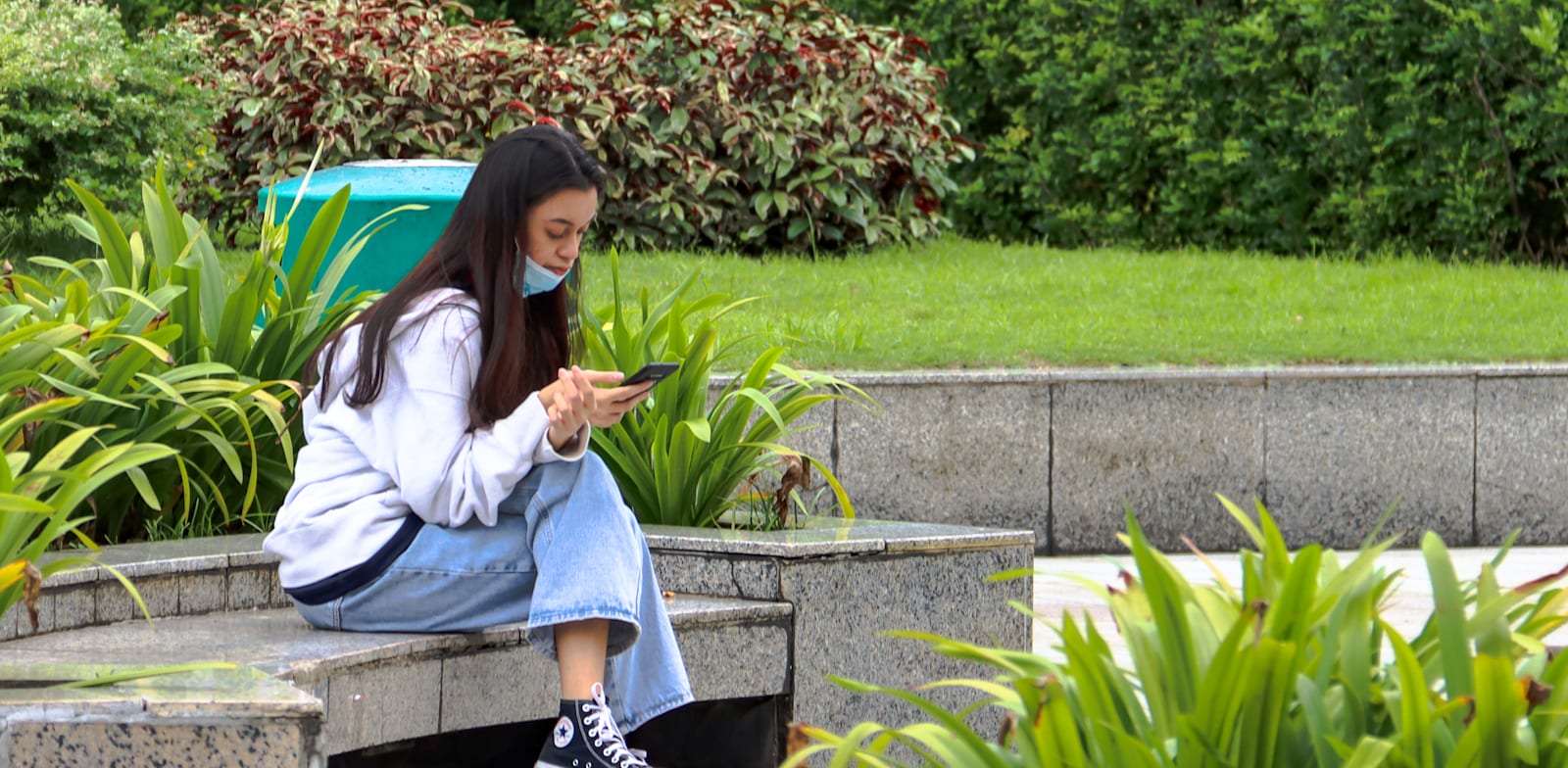 אישה צעירה בטלפון שלה בסינגפור / צילום: Shutterstock, ד''ר דייויד סינג