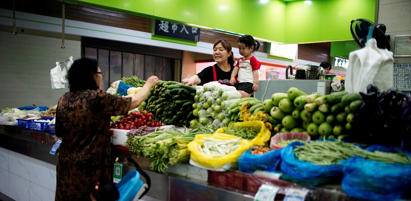 אישה עושה קניות בשוק בסין / צילום: Reuters, אלי סונג