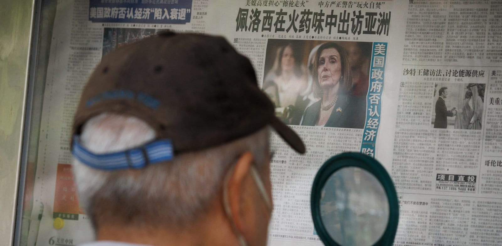 אזרח סיני קורא על ביקור ננסי פלוסי בעיתון, השבוע / צילום: Reuters, Thomas Peter